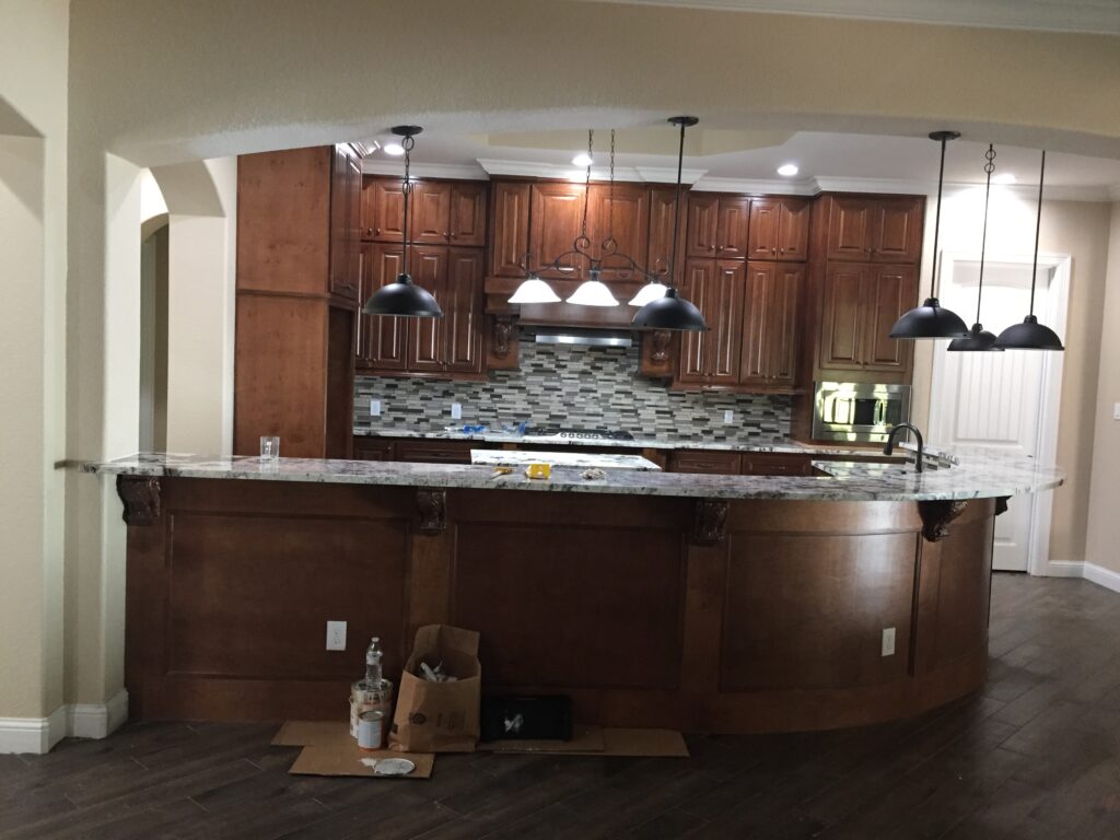 A kitchen with brown cabinets and white counter tops.