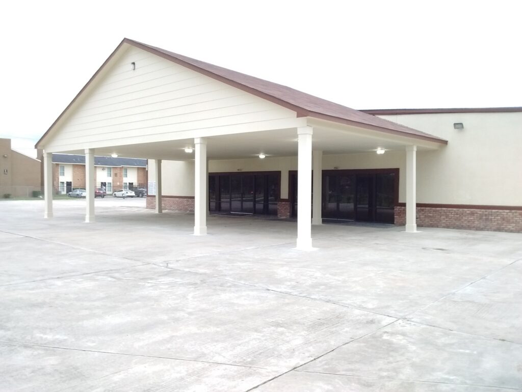 A large building with two doors and a carport.