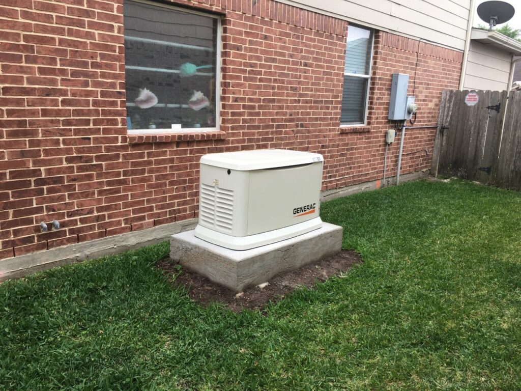 A generator sitting in the grass outside of a building.