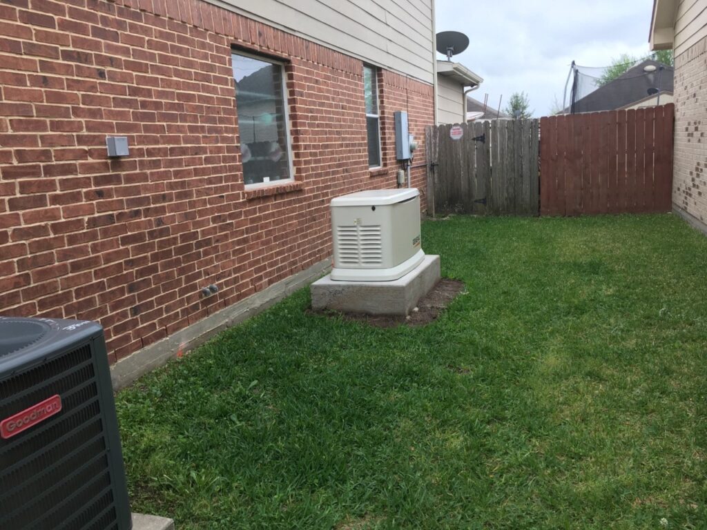 A small air conditioner is in the grass outside.