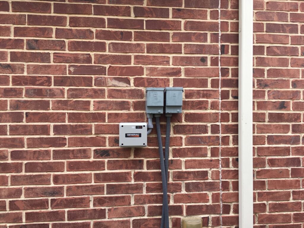 A brick wall with two electrical boxes on it.