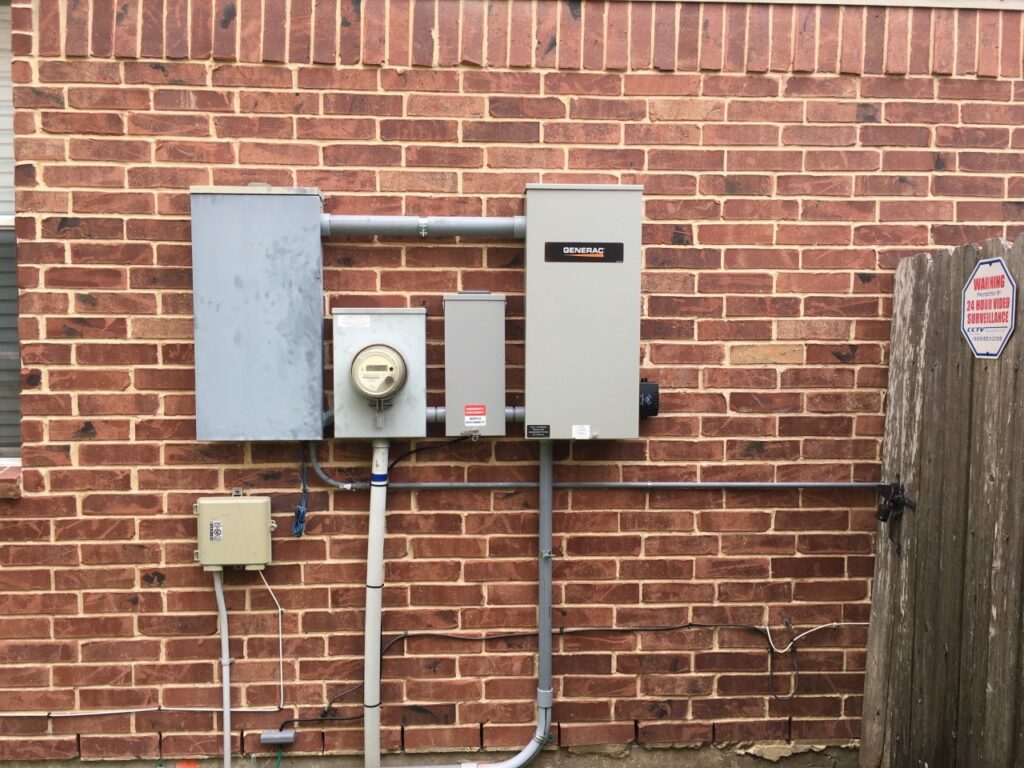 A power box and meter on the side of a brick wall.