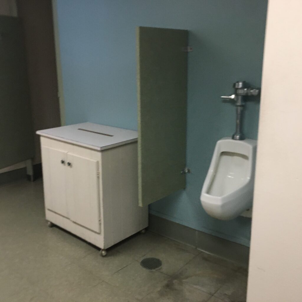 A bathroom with a urinal and toilet in it