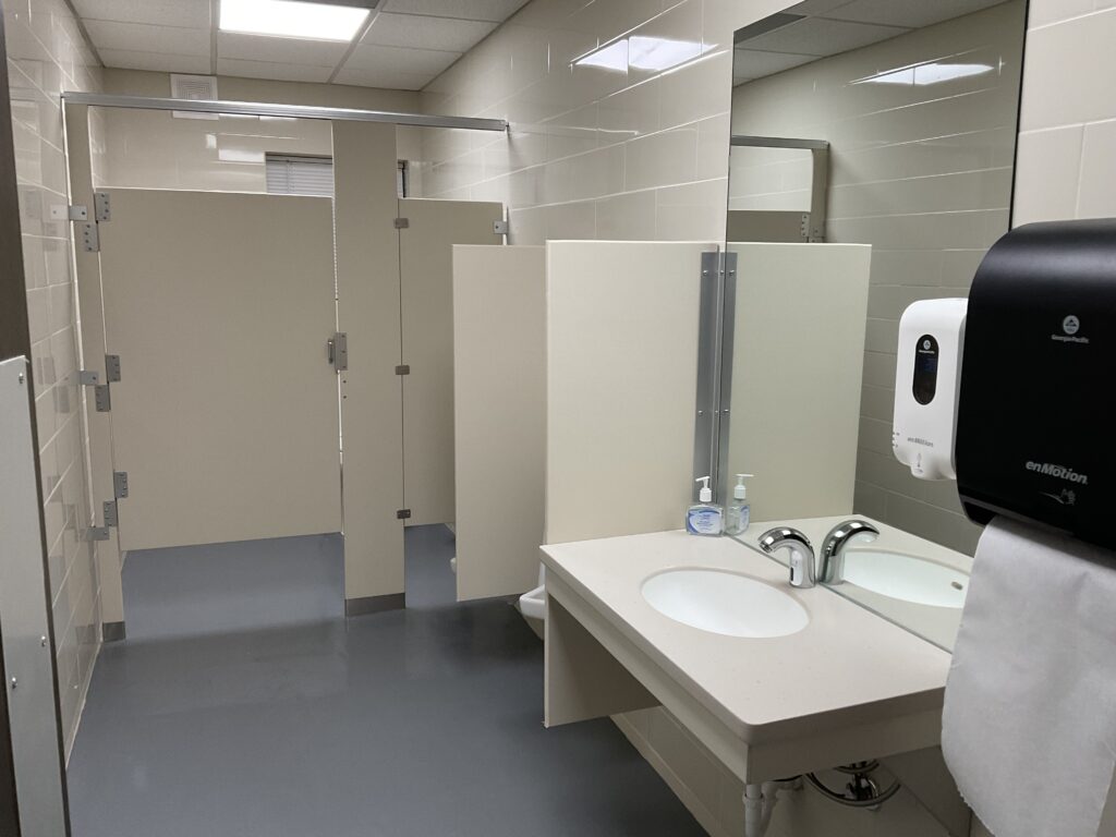 A bathroom with a sink, mirror and toilet.